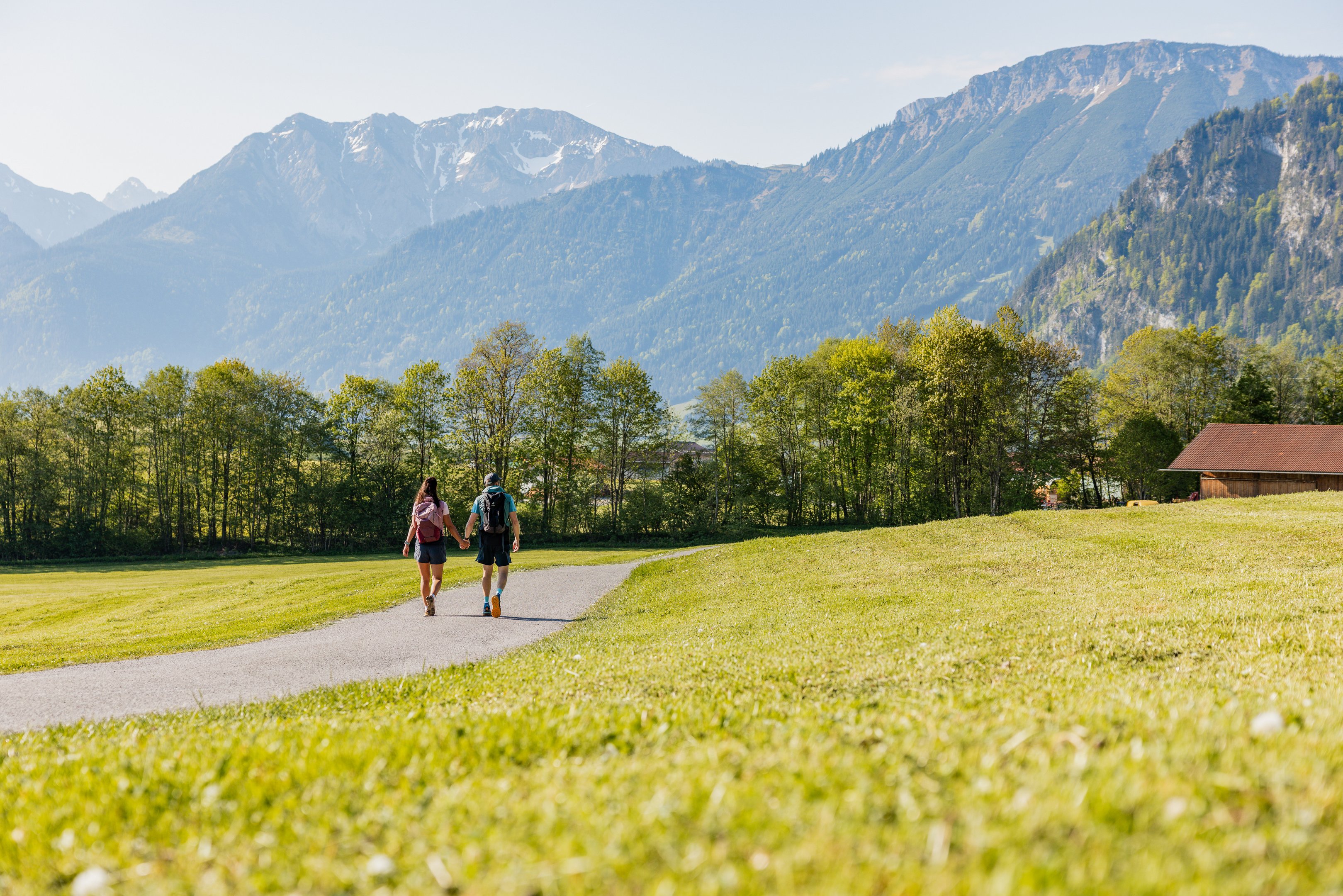 Wanderer im Tal mit Bergen im Hintergrund