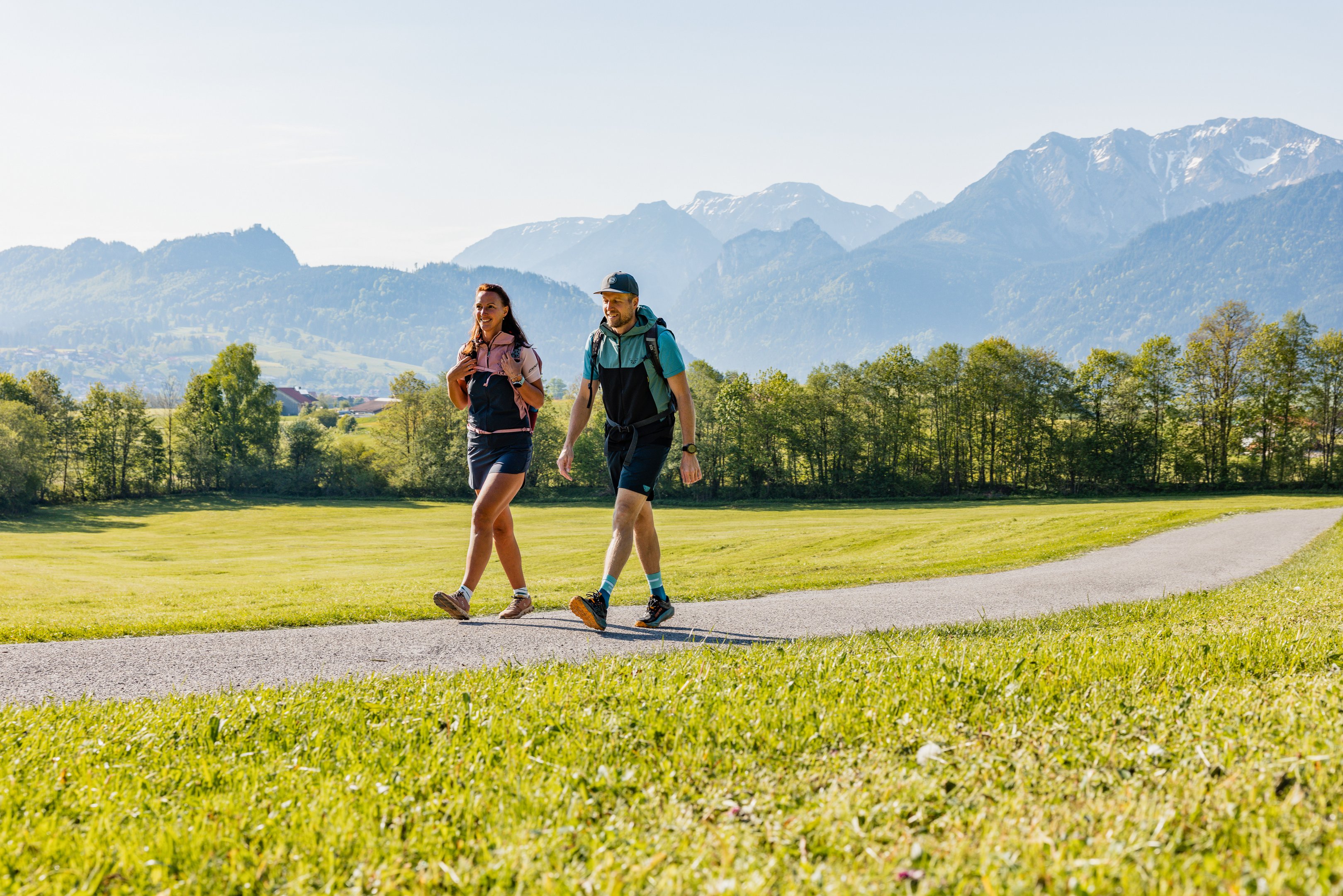 Wanderer im Tal mit Bergen im Hintergrund